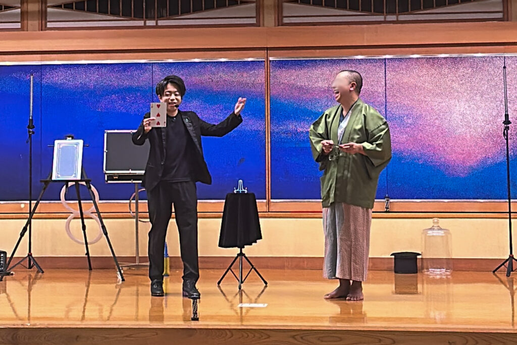 富士山温泉ホテル鐘山苑にてインドネシア人のゲストと共に参加型カードマジックを演じるCrystal Magician® Michel