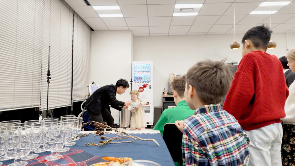 外資系ファンドのファミリーイベントにてCrystal Magician® Michelの持つカップに水を注ぐマジックショーのゲストの女の子