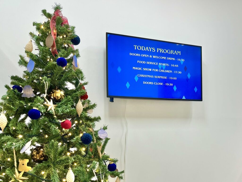 外資系ファンドのファミリーイベント入り口のクリスマスツリーとイベントプログラム