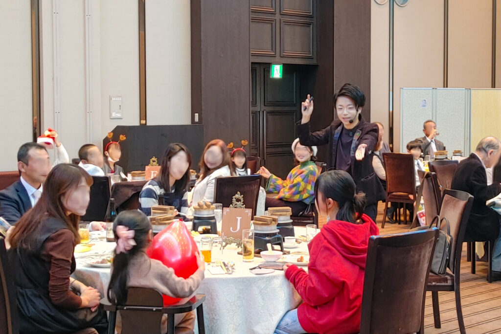 ザ・ウィングス海老名でマジックに使う風船を手に取ったゲストに質問をするCrystal Magician® Michel