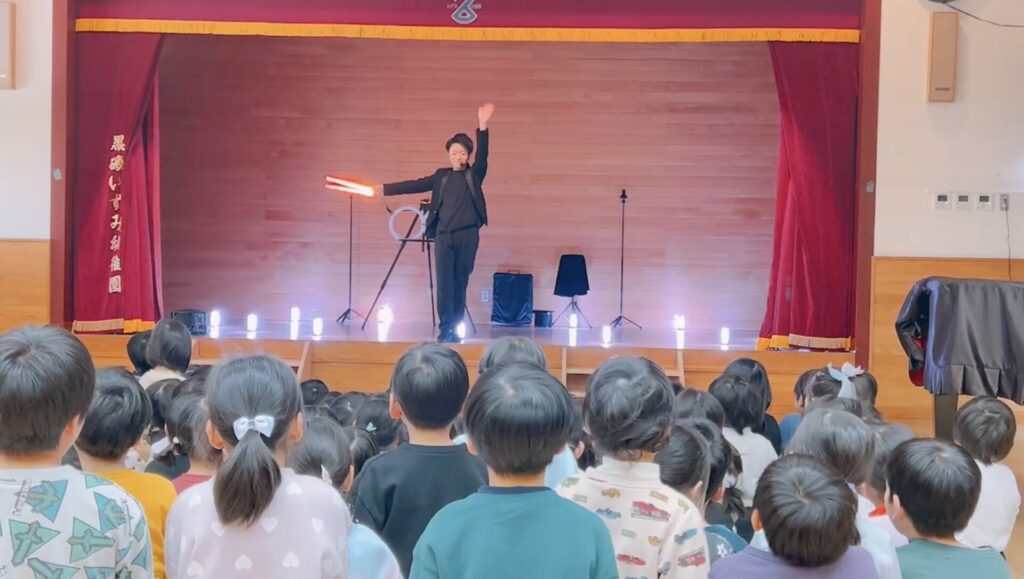 栃木県那須塩原市の黒磯いずみ幼稚園でLEDショーを演じた後に子どもたちに手を振るCrystal Magician® Michel