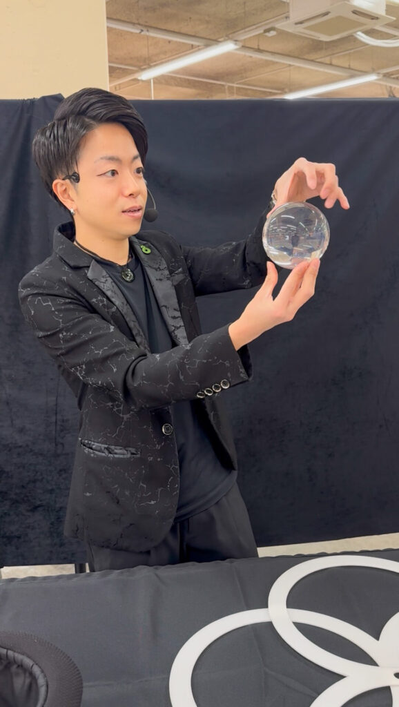 北海道北斗市のイオン上磯での携帯ショップイベントにて、水晶玉を使ったパフォーマンスを演じるCrystal Magician® Michel
