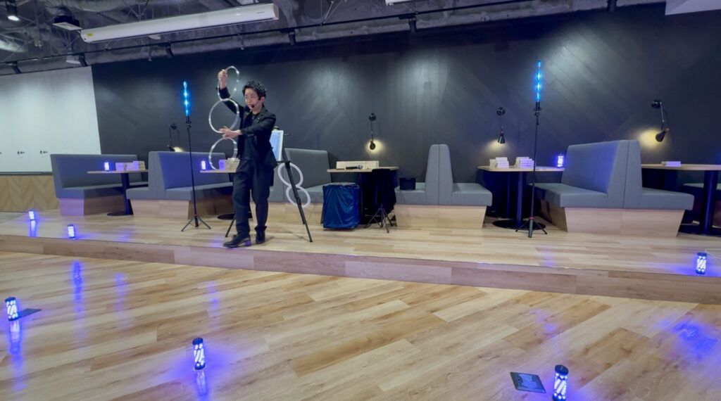 株式会社テラスカイ・テクノロジーズのオフィスで開かれた5周年記念イベントにて、LED演出と共に金属のリングを使ったステージマジックを演じるCrystal Magician® Michel