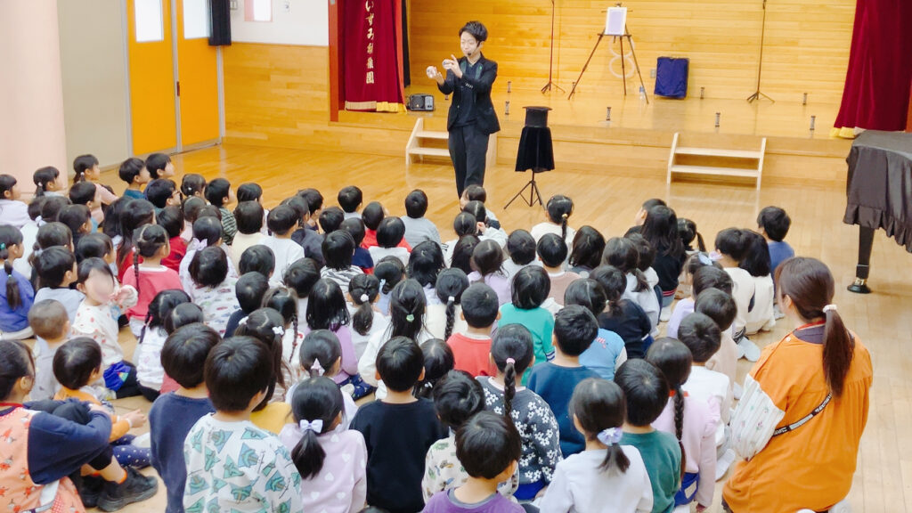 栃木県那須塩原市の黒磯いずみ幼稚園で水晶玉パフォーマンスを演じるCrystal Magician® Michelとそれを観る子どもたち