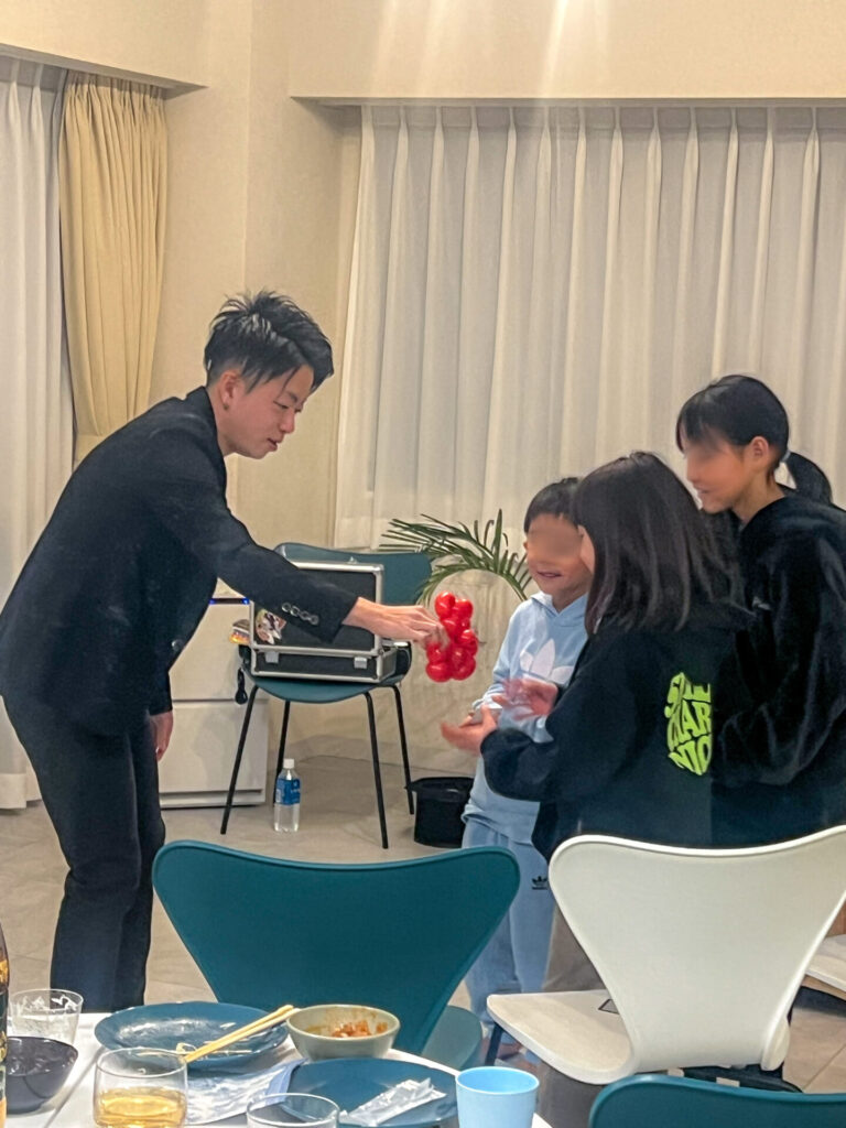 2026年2月7日、茅ヶ崎市のマルソルCSビーチホテル様のプライベートショーの後、子どもたちにバルーンアートをプレゼントするCrystal Magician® Michel