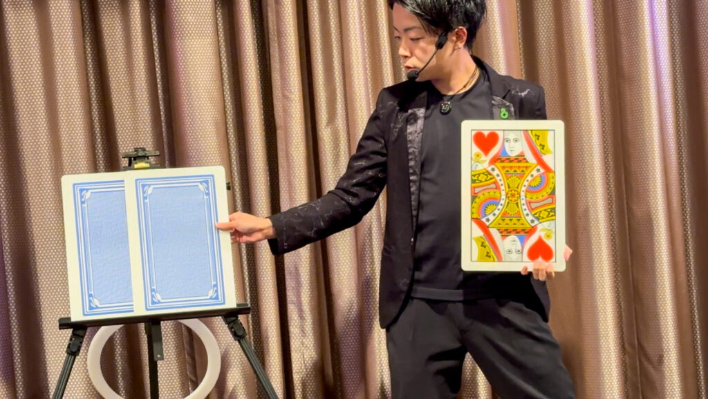 2026年2月2日、ザ・ウィングス海老名で開かれた海老名トラック地区会新年会にて大きなトランプを使ったステージマジックを演じるCrystal Magician® Michel
